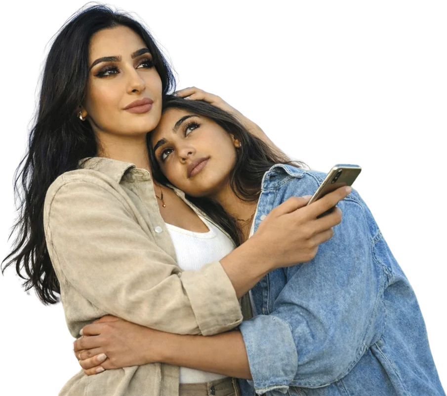 A mother and daughter embracing while checking a phone together